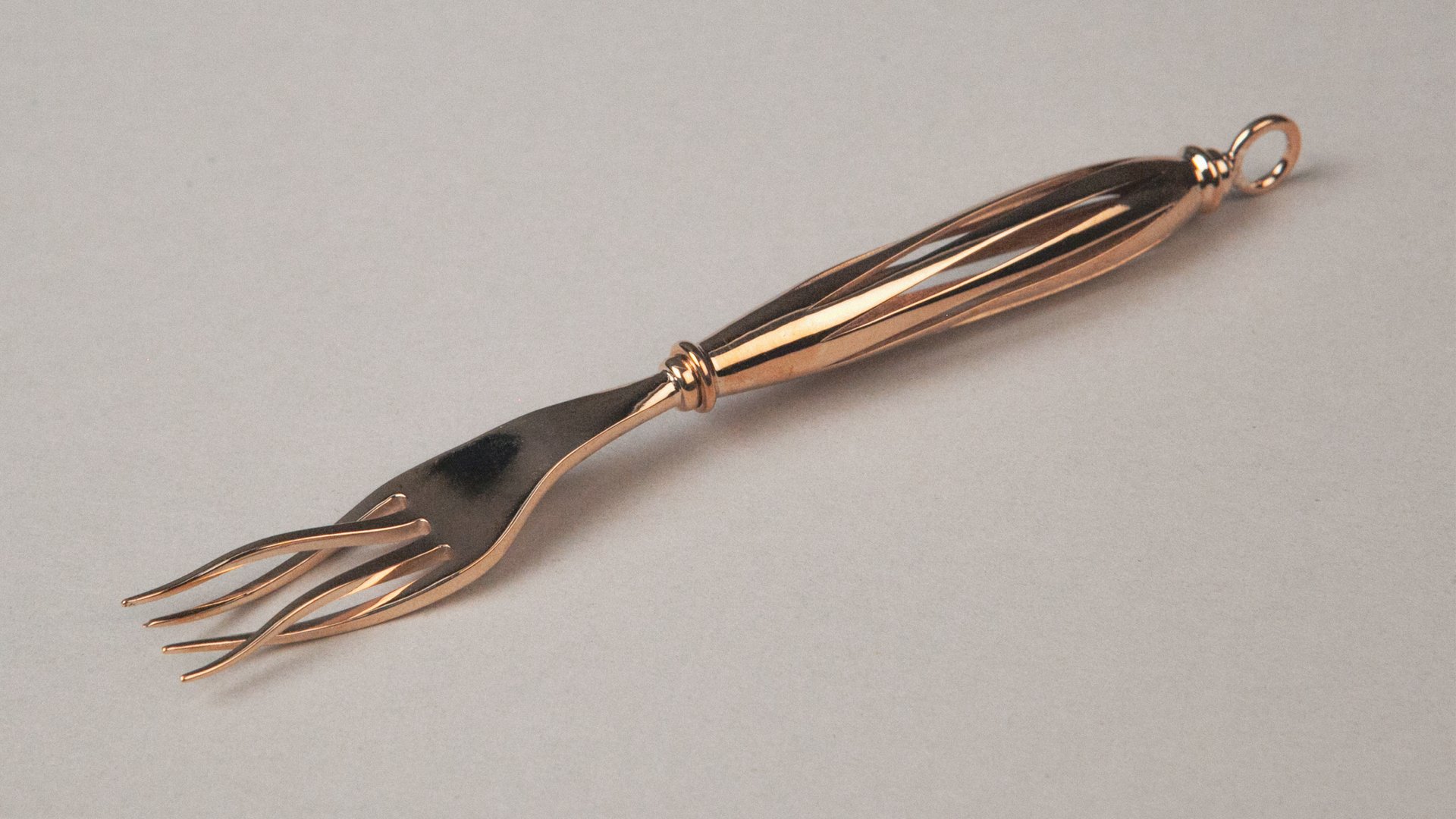 Copper-toned serving fork with a twisted openwork handle